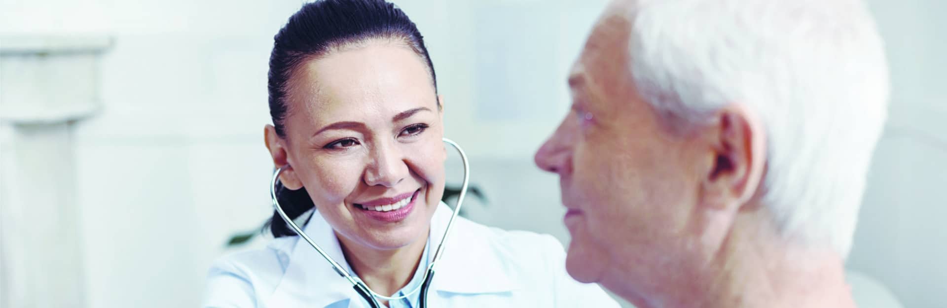 Nurse working wearing stethoscope checking on resident